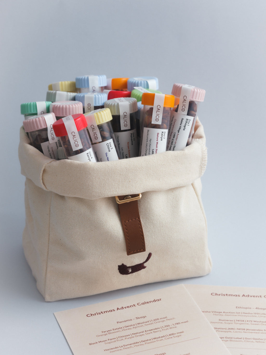 Calico Christmas Calendar 2026 with coffee tubes in the open canvas bag